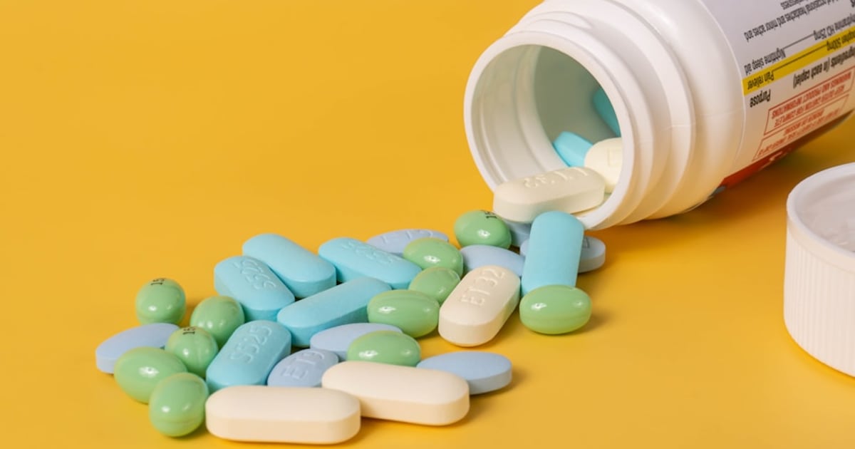 Mixed pills spilling out of a pill bottle.