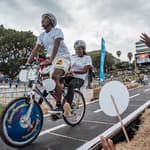 Team 'Smoothoperators' rides down the obstacle course on their custom-built bike, cheered on by the crowd