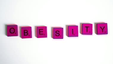 Obesity Spelled on Purple Scrabble Tiles