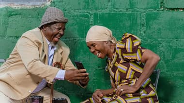 Elderly couple happily using a smartphone together