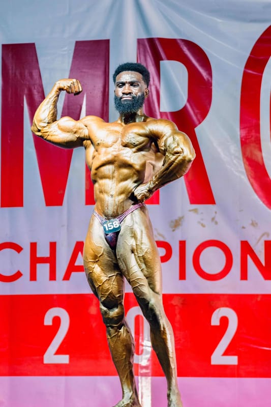 Philip Guya posing on stage at Mr 001 Championship 2025