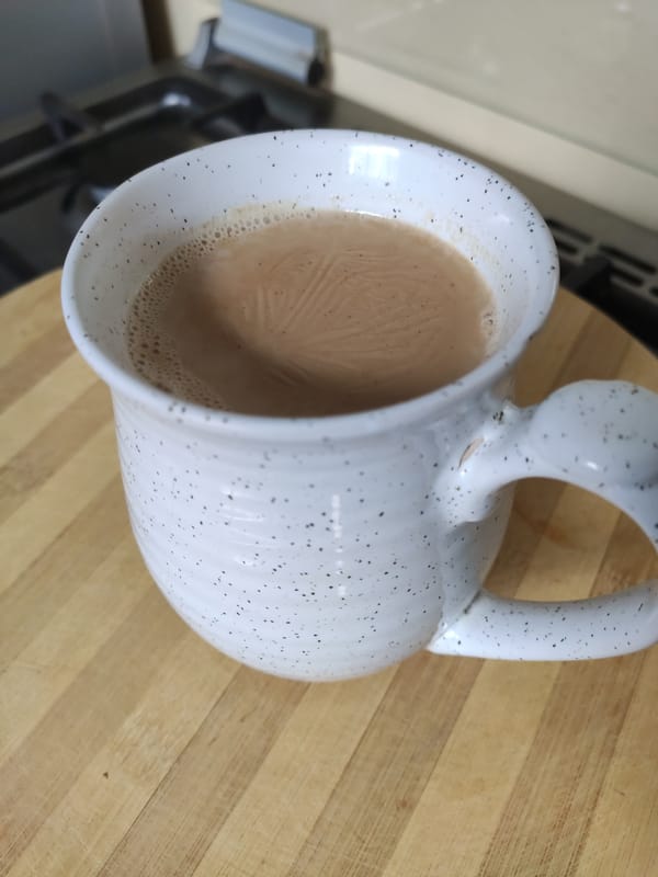 Steaming hot chai ya maziwa in a handmade ceramic mug
