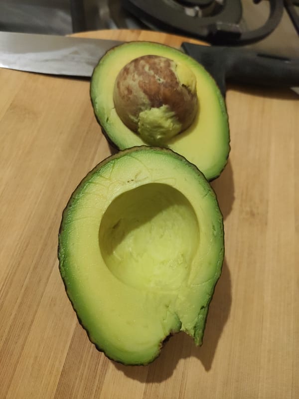 Fresh ripe avocado halved to show the pit and flesh
