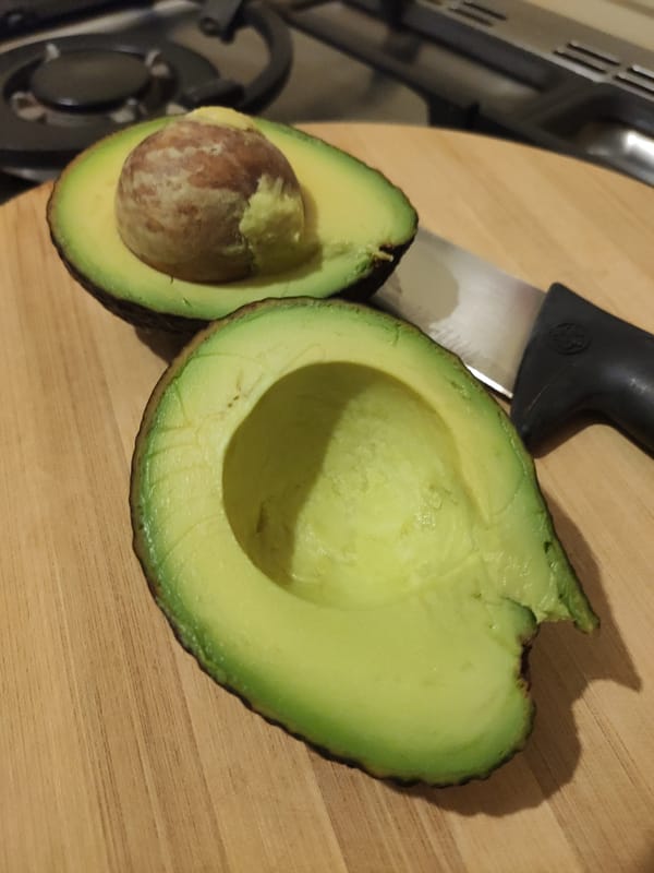 Halved avocado with the pit still in one side