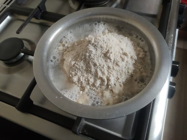 Maize flour (unga) added to boiling water to start making ugali