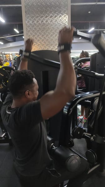 Desmond Karani performing lat pulldowns at the gym