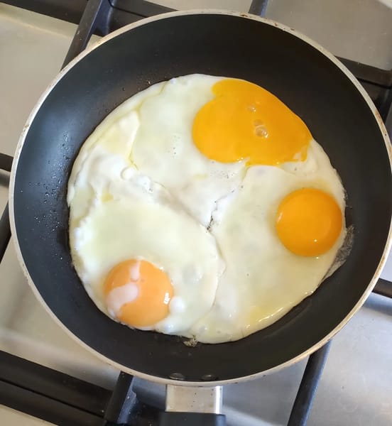 Cracked kienyeji and cage eggs showing yolk color differences