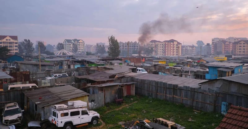 Aerial view of Nairobi informal settlement with visible smoke and haze from burning waste
