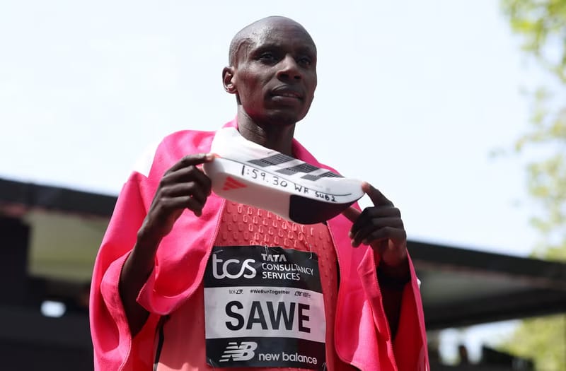 Sabastian Sawe holding shoe marked sub-2 after London Marathon world record