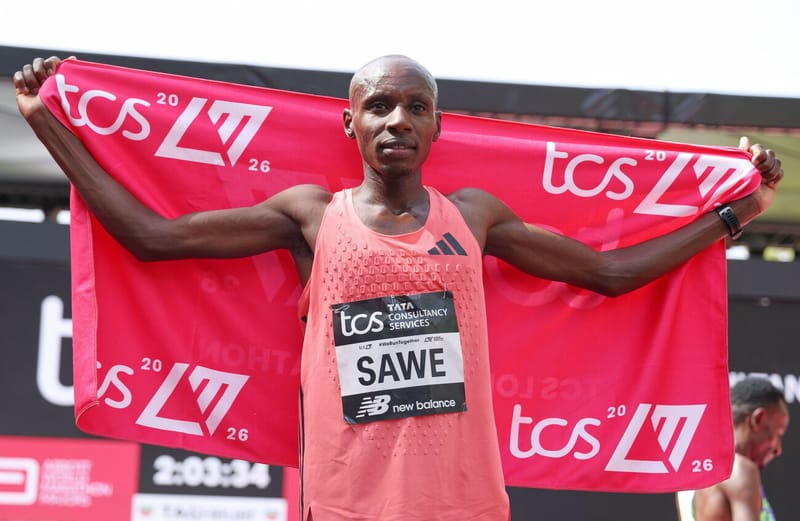 Sabastian Sawe holding the TCS London Marathon 2026 flag after becoming the first athlete to officially run a sub-two-hour marathon.